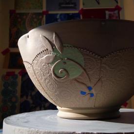 Bowl in process with slip-sponge, underglaze, and slip-trail deco
